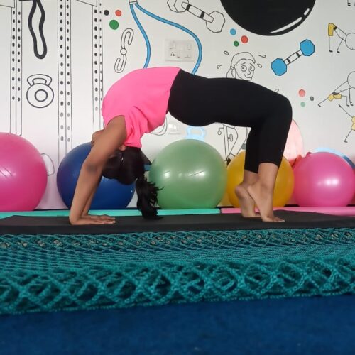 A Young Enthusiast is Practicing Yoga in our kids' fitness classes. A child in a yoga bridge pose in our kids fitness center.