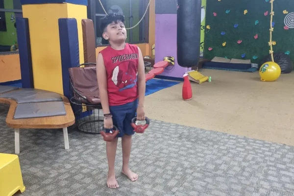 Young child at a Jump-n-rise , kids fitness center lifting weights safely